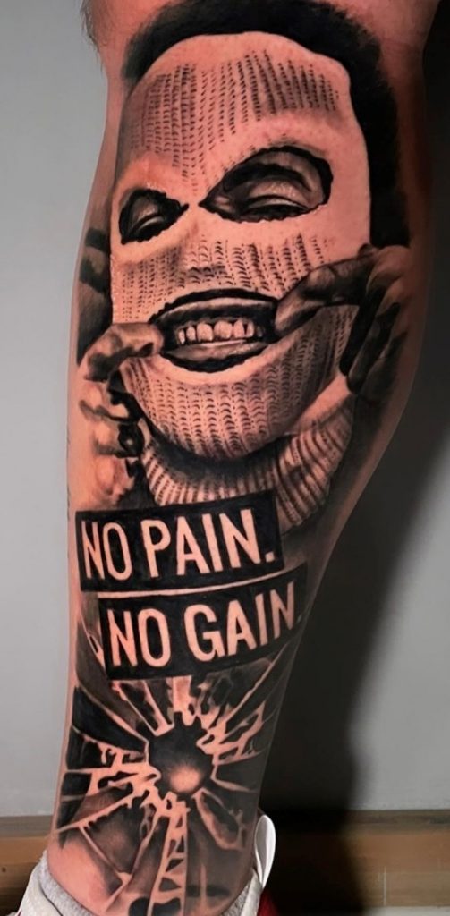 Tattoo von einem maskierten Gesicht auf der Wade