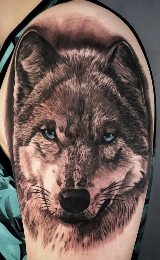 Tattoo von einem Wolf auf dem Oberarm